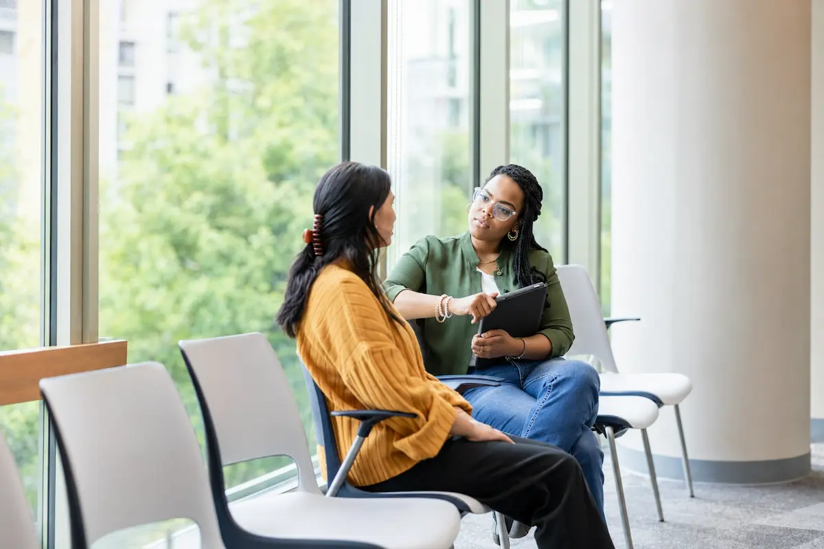 Psychiatrist listening to a patient during an out-of-network psychiatry consultation in a bright, comfortable office.